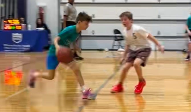 Kids playing basketball one-on-one indoor game